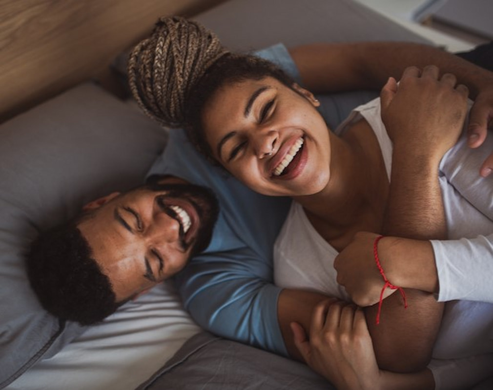 stel op bed lachend stel op bed lachend